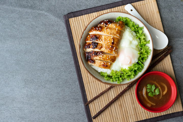 Chicken rice or Teriyaki Chicken and Egg onsen in gray bowl with Oyster sauce on table.