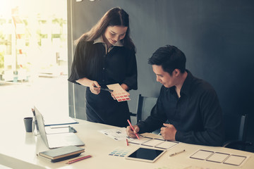 Two graphic designers creative drawing website ux app development and application for mobile phone in the office.