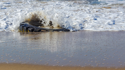 wave crashing over a used truck tyre