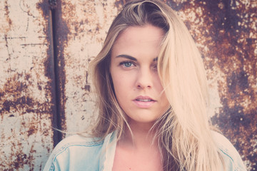 Fototapeta premium beautiful woman or teenager of blue eyes looking at the camera seriously - portrait of 20s alone in a urban street