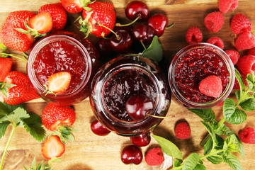 assortment of jams, seasonal berries, cherry, mint and fruits in glass jar
