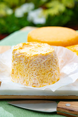 French cheeses collection, Langres and Le peche des bons peres cheeses served on white marble plate outdoor in green garden