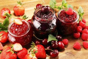 assortment of jams, seasonal berries, cherry, mint and fruits in glass jar