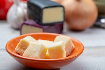 Mini black and dark red waxed cheddar cheeses with strong flavor made from West Country milk and and age-old methods with onion and garlic in England