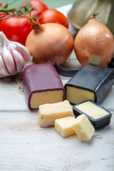 Mini black and dark red waxed cheddar cheeses with strong flavor made from West Country milk and and age-old methods with onion and garlic in England