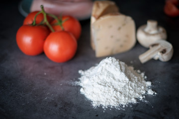 Food ingredients for pizza at black background as tomatoes,cheeze,mushrooms etc