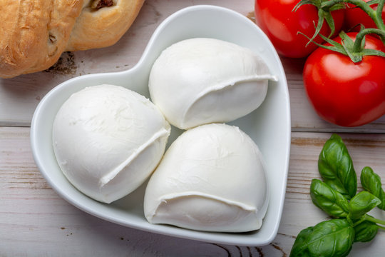 Love mozzerella, balls of buffalo mozzarella, soft Italian scheese made from the milk of Italian Mediterranean buffalo in heart shaped plate