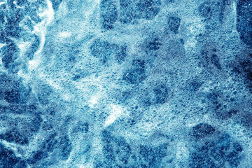 Water foam texture. Blue bubble spa washing background. Rough river water on a dam backdrop.