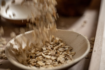 Falling oat flakes in bamboo bowl
