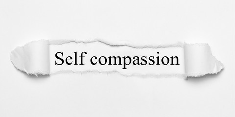 Self compassion on white torn paper