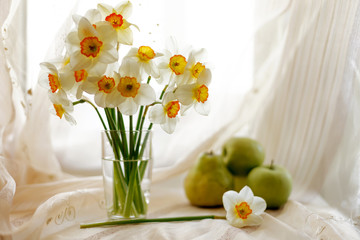 Still life with white daffodils on  windowsill.