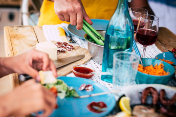 great table of food with a lot of people taking, eating and drinking - senior and mature holding a glass of vine to celebrate - family party at home indoor out outdoor - caucasian people 