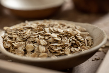 Closeup oat flakes in bamboo bowl