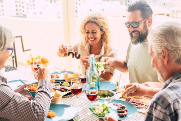beautiful moment of family lifestyle at home eating and drinkng food or drinks at home on the table - man with sunglasses tking a vegetables - table full of food and salad outdoor