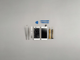 Broken and cracked screen smartphone prepairing to repair and replace new screen on technician desk with copy space