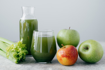 Fresh green smoothie with ingredients. Superfood and detox drink concept. Fresh apples and cerely on white background. Healthy drinking