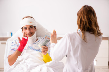 Young doctor examining injured patient 