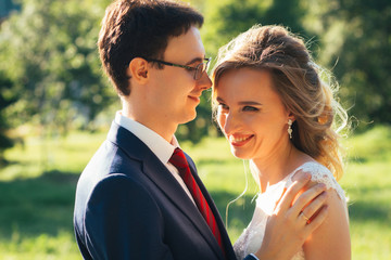 Obraz premium bride and groom embracing on nature background