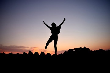 silhouette of a girl jumping in the sunset