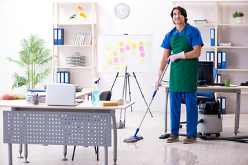 Male handsome professional cleaner working in the office 