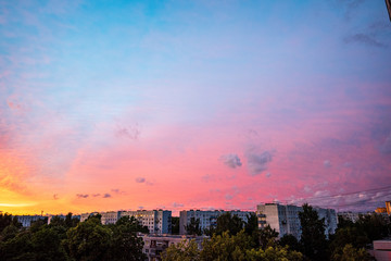 Obraz premium dramatic red sunset colors in the sky above trees and fields