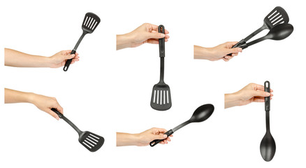 Hand with black plastic kitchen utensils, set and collection.