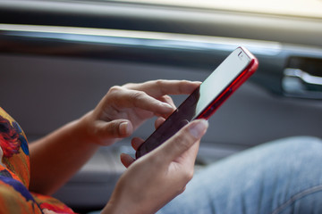The woman is using a mobile phone to help navigate or GPS while sitting in the car.