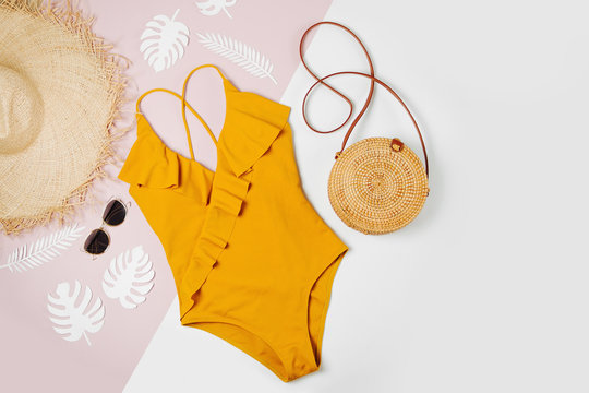Fashion bamboo bag and sunglass, straw hat and swimsuit. Flat lay, top view. Summer Vacation concept.