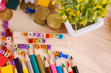 Business Campaign Concept background, colorful cube with word MARKETING PLAN on wooden desk