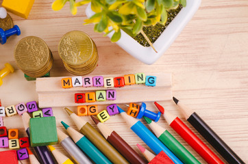 Business Campaign Concept background, colorful cube with word MARKETING PLAN on wooden desk