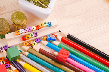 Business Campaign Concept background, colorful cube with word MARKETING PLAN on wooden desk