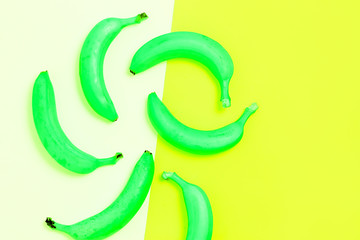 Closeup view of top yellow bananas on bed blue and pink background