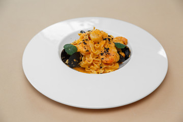 Mediterranean food. Seafood spaghetti with seafood. On a wooden background. beige background