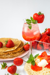 Summer strawberry season. Strawberries with pancakes and ice cream and Water with ice and strawberry syrup. Desserts