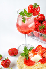 Summer strawberry season. Strawberries with pancakes and ice cream and Water with ice and strawberry syrup. Desserts