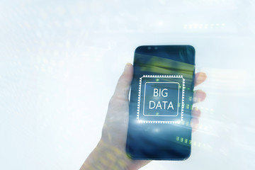 Woman Hand holding mobile phone. Server room background. Inscription on a virtual screen: Big Data. Double exposure.
