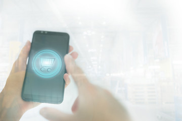 Shopping basket on a mobile phone screen. Woman Hand holding mobile phone on Supermarket blur background