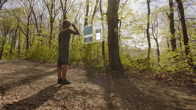 Girl uses augmented reality to learn about the tree in the forest
