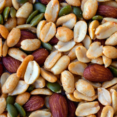 Square background made of peanuts, almond, pumpkin seeds top view