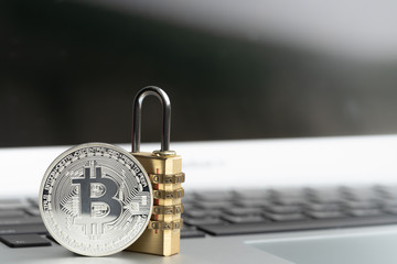 Bitcoin(BTC) coin with padlock lying on computer background. Bitcoin security. digital cyber safety or security encryption, Blockchain technology to encode online information or data protection.