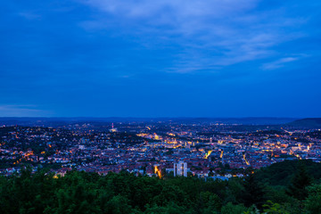 Germany, Houses and streets of stuttgart city glowing in evening dawning mood in the middle of green nature landscape from above monte scherbelino