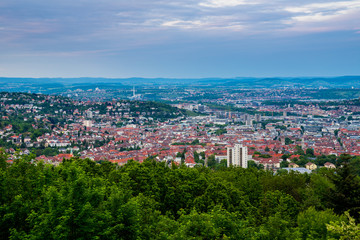 Fototapeta na wymiar Germany, Houses of city stuttgart in valley surrounded by many hills and mountains forested with green trees in beautiful nature landscape