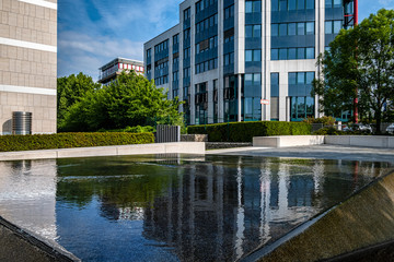 Fototapeta na wymiar modernes Bürogebäude mit Spiegelung in Wasserbecken