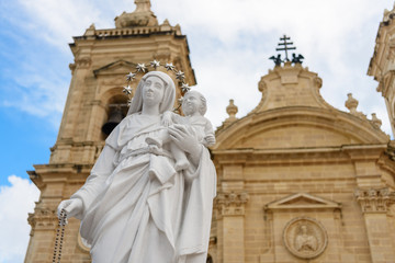 Fototapeta na wymiar Statue of the Virgin Mary with child Jesus outside the Parish Church in Xaghra, Gozo, Malta.