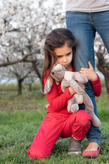 domestic violence. Upset, sad child, frightened girl in stress holding on to the parent. Girl, afraid! Loneliness, the child is afraid to be alone.