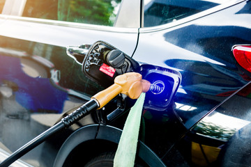 hand refilling the black car with fuel at the gas station. oil and gas energy.