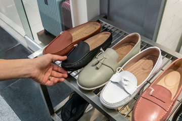Hand holding and selecting fashion shoes