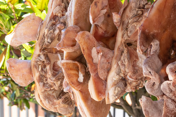 Processed pork jerky hangs on the butcher shop's windshield