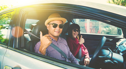 Naklejka premium Happy moment couple asian man and woman sitting in car. Enjoying travel concept.
