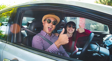 Happy moment couple asian man and woman sitting in car. Enjoying travel concept.